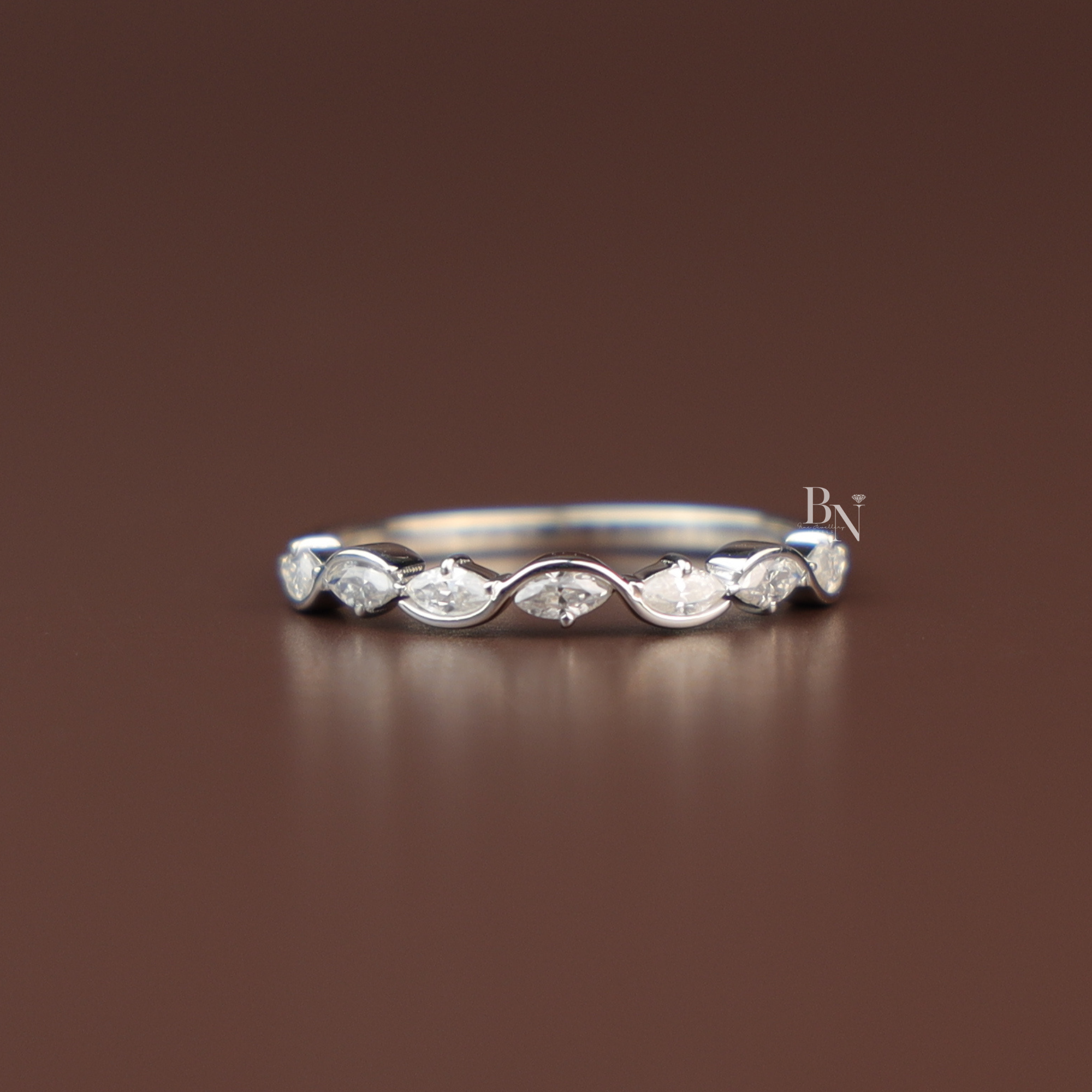 A dainty marquise cut lab grown diamond wave band in polished white gold, featuring an organic scalloped design
