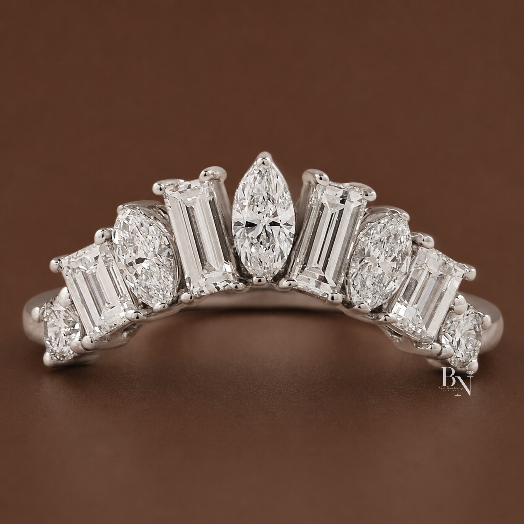 Curved tiara lab diamond wedding band with alternating marquise and baguette stones. Showcasing 0.95 carats on a delicate 1.6mm 14K gold band, this luxury nesting ring is styled with a pear engagement ring and shown in multiple gold tones.
