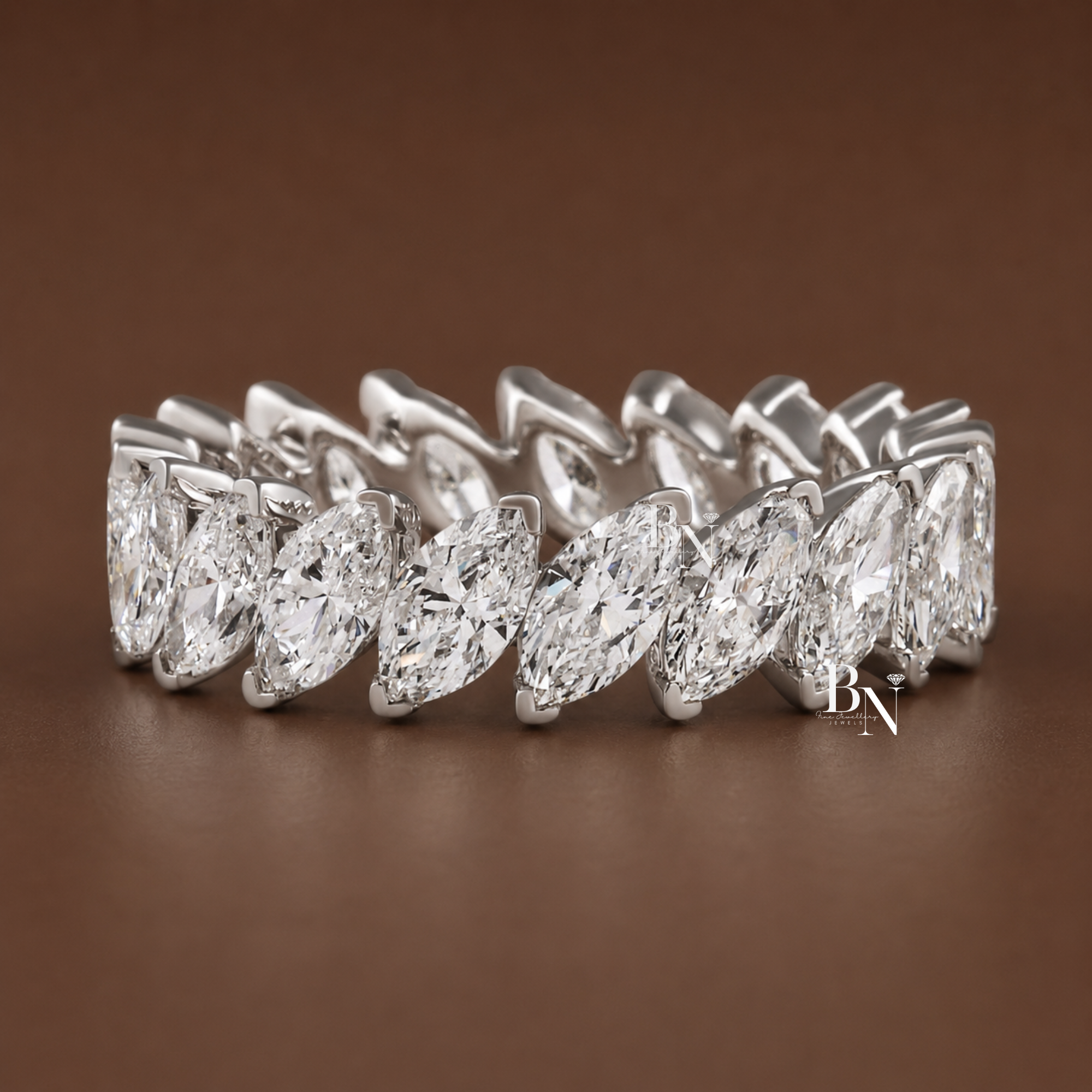 Angled marquise cut lab diamond full eternity band in a closed basket setting. Showcasing 3 total carats on a 5.2mm 14K solid gold band, this slanted luxury bridal stacking ring is displayed on hand and isolated in multiple gold tones.