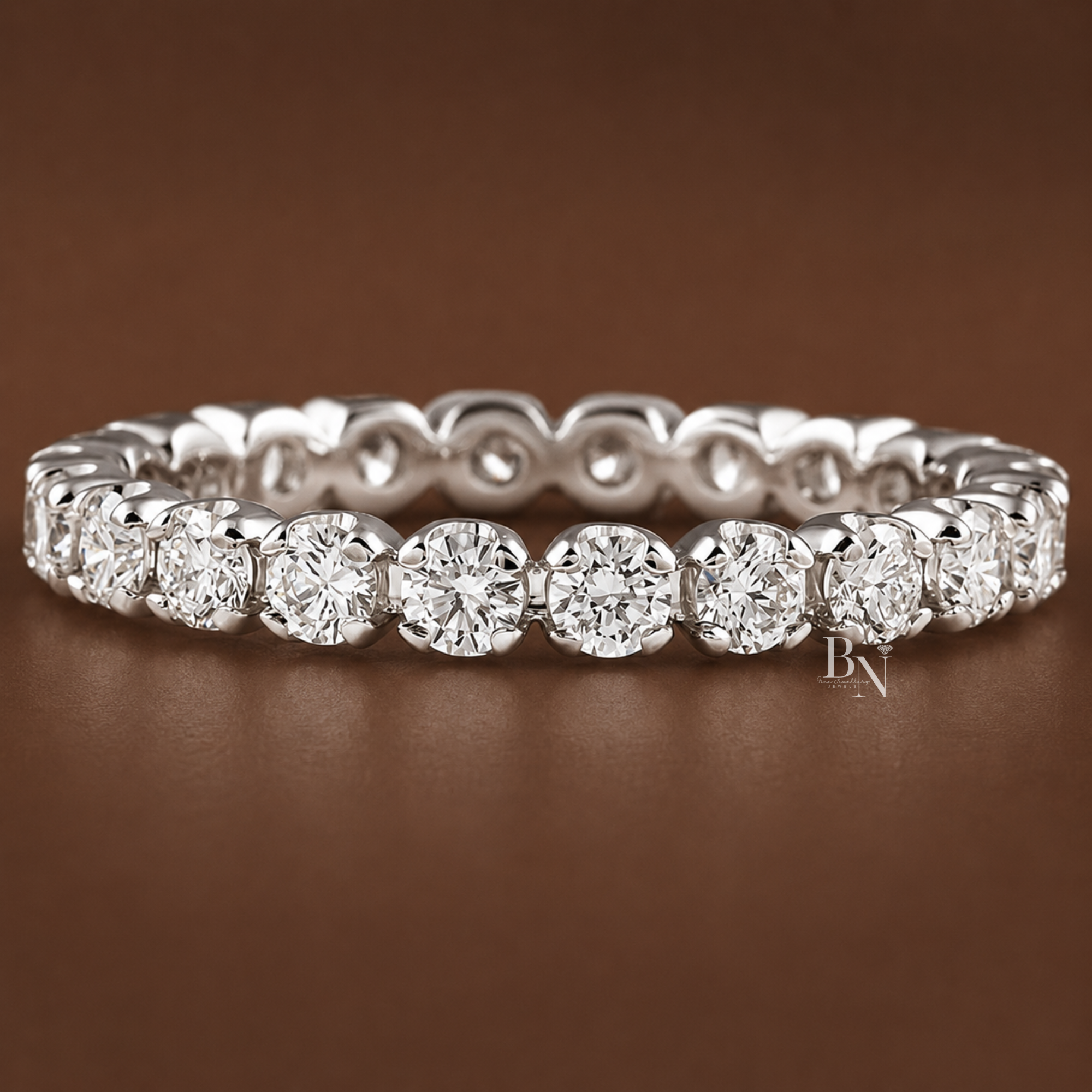 A 2.6mm wide eternity band featuring round brilliant cut lab diamonds in an illusion-style four-prong setting, handcrafted in gold for a defined, sparkling look.