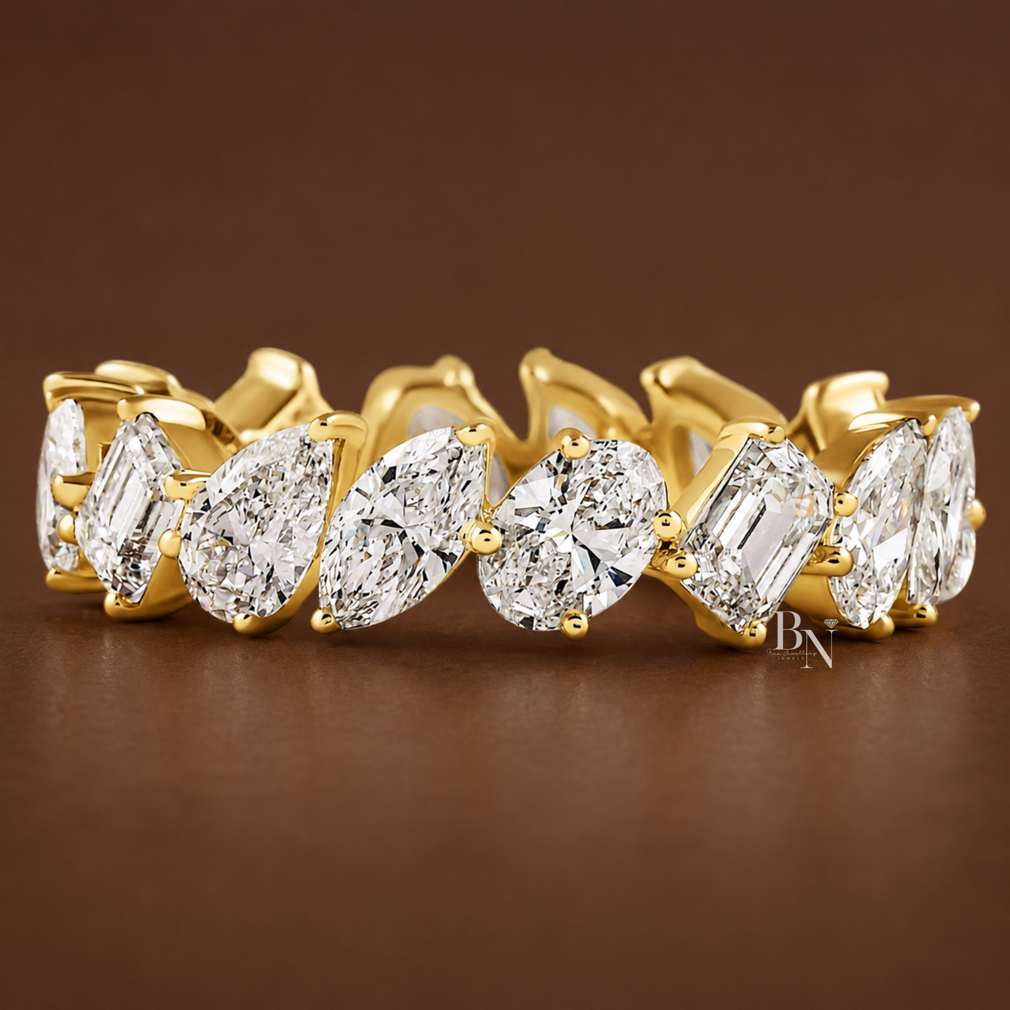 Front view of a white gold eternity band featuring a continuous mixed-cut layout of slanted oval, emerald, pear, and marquise lab diamonds.