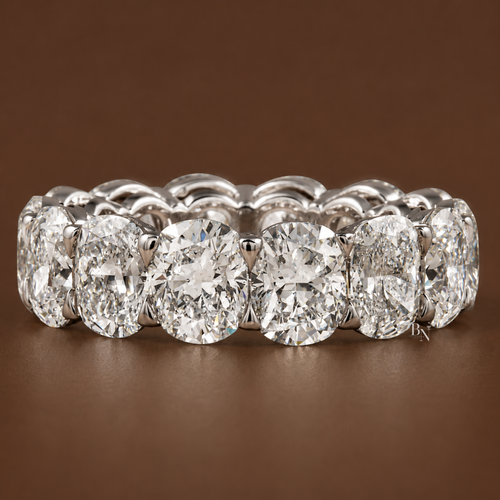 Face-up angled view of a white gold full eternity band featuring 10.30 carats of cushion-cut lab-grown diamonds set in open airline baskets.