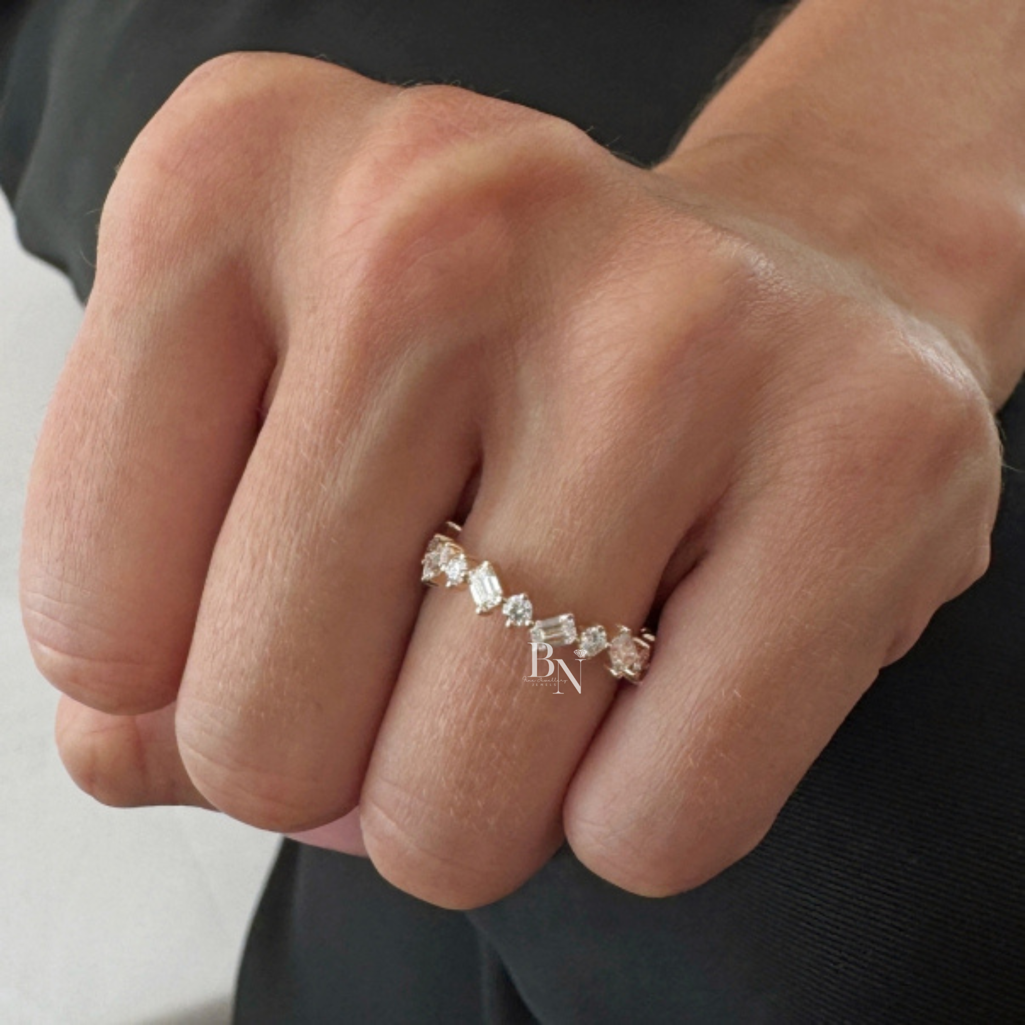 Angled view of a 14K yellow gold eternity band featuring a zig-zag pattern of alternating emerald-cut and round brilliant lab-grown diamonds.