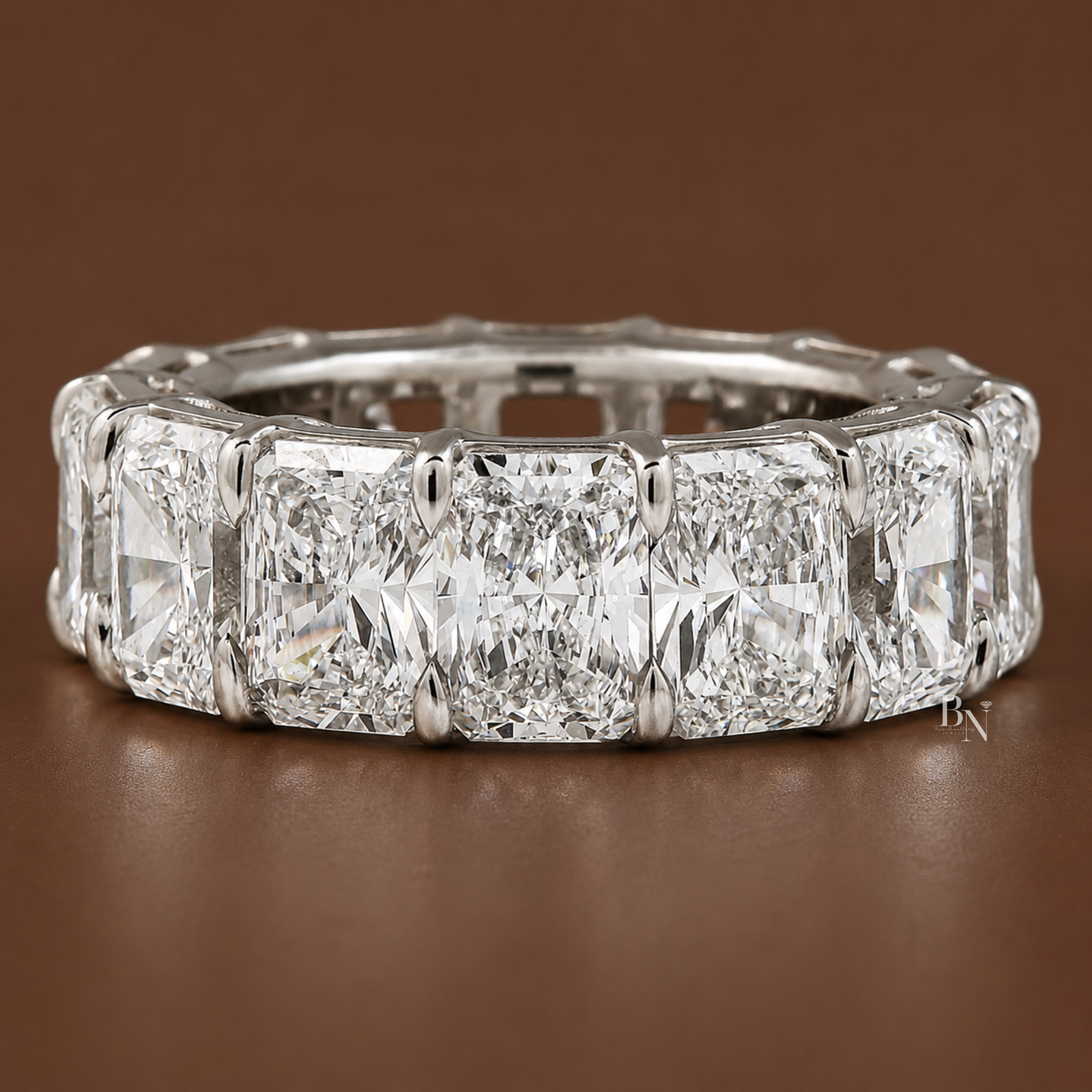 Angled side profile of a massive white metal eternity band featuring large radiant-cut lab-grown diamonds in an open airline basket setting.