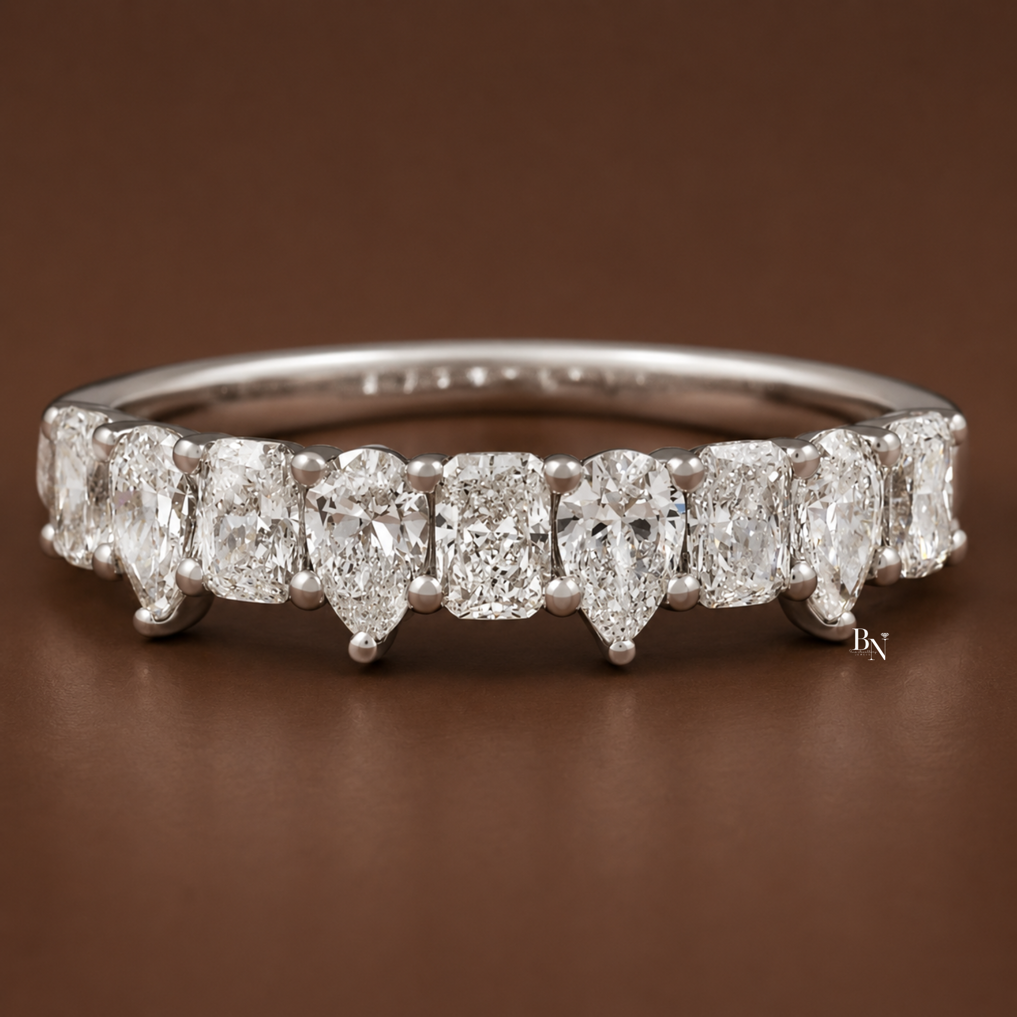 Front view of a yellow gold 9-stone half eternity band showcasing alternating pear and radiant lab diamonds.