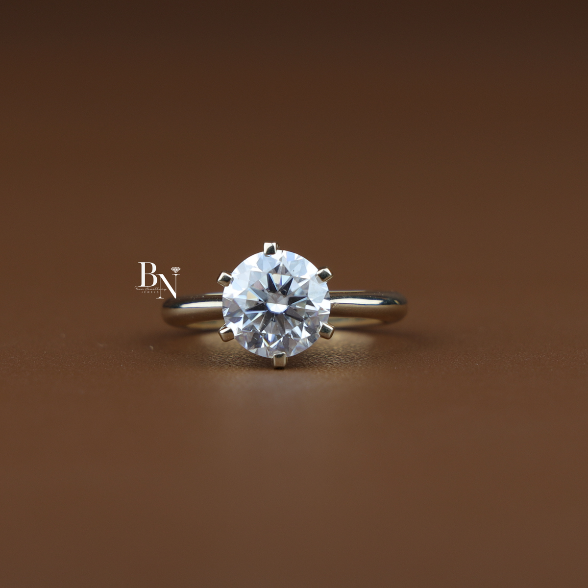Top-down view of a 3 carat round cut lab-grown diamond engagement ring in a classic 6-prong setting on a smooth gold band.