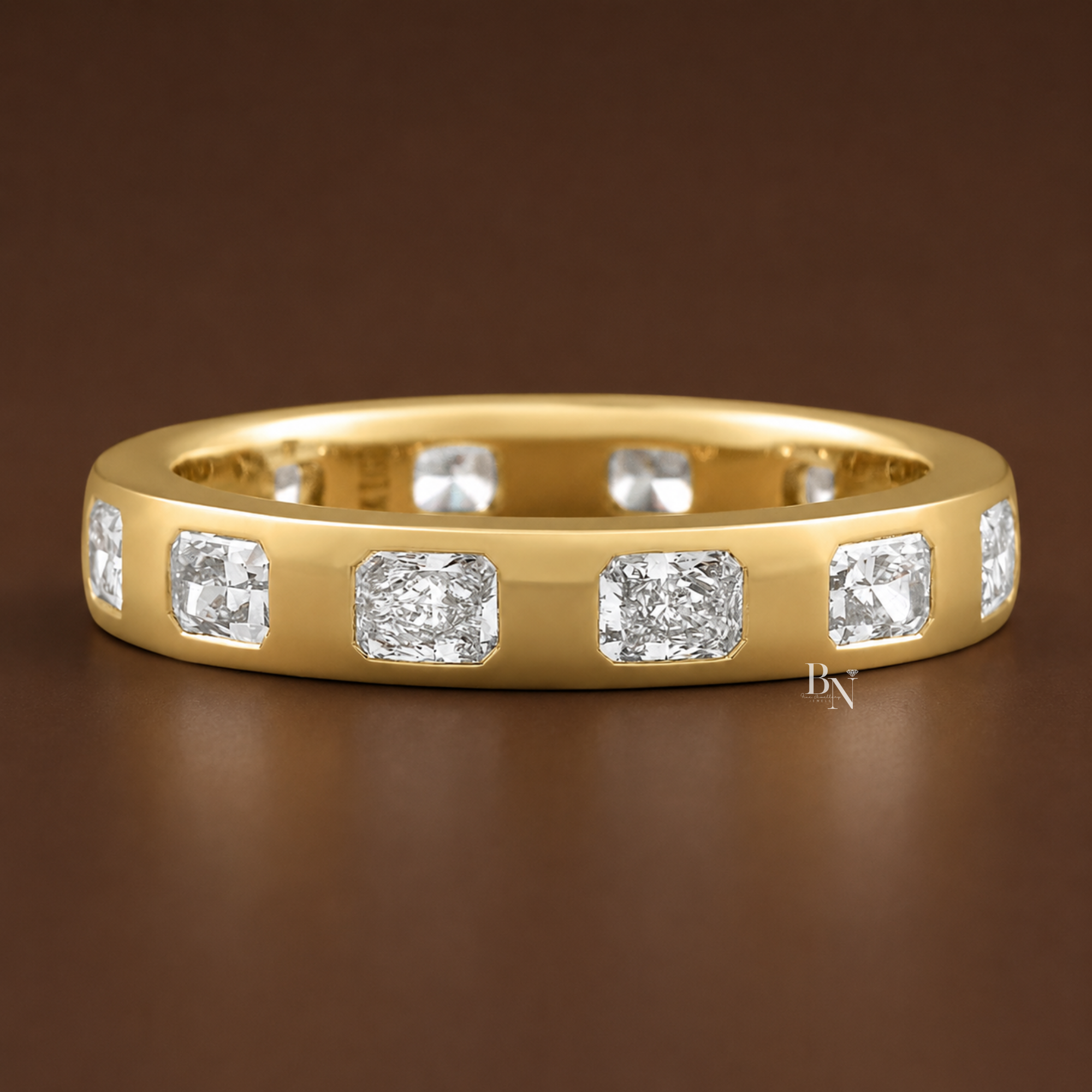 1.20 carat total weight radiant cut lab diamond burnished set wedding band. Crafted in 14k gold, this 3.4mm wide comfort fit ring features flush set stones spaced evenly around the band for a sleek, modern bridal stack and fine jewelry aesthetic.