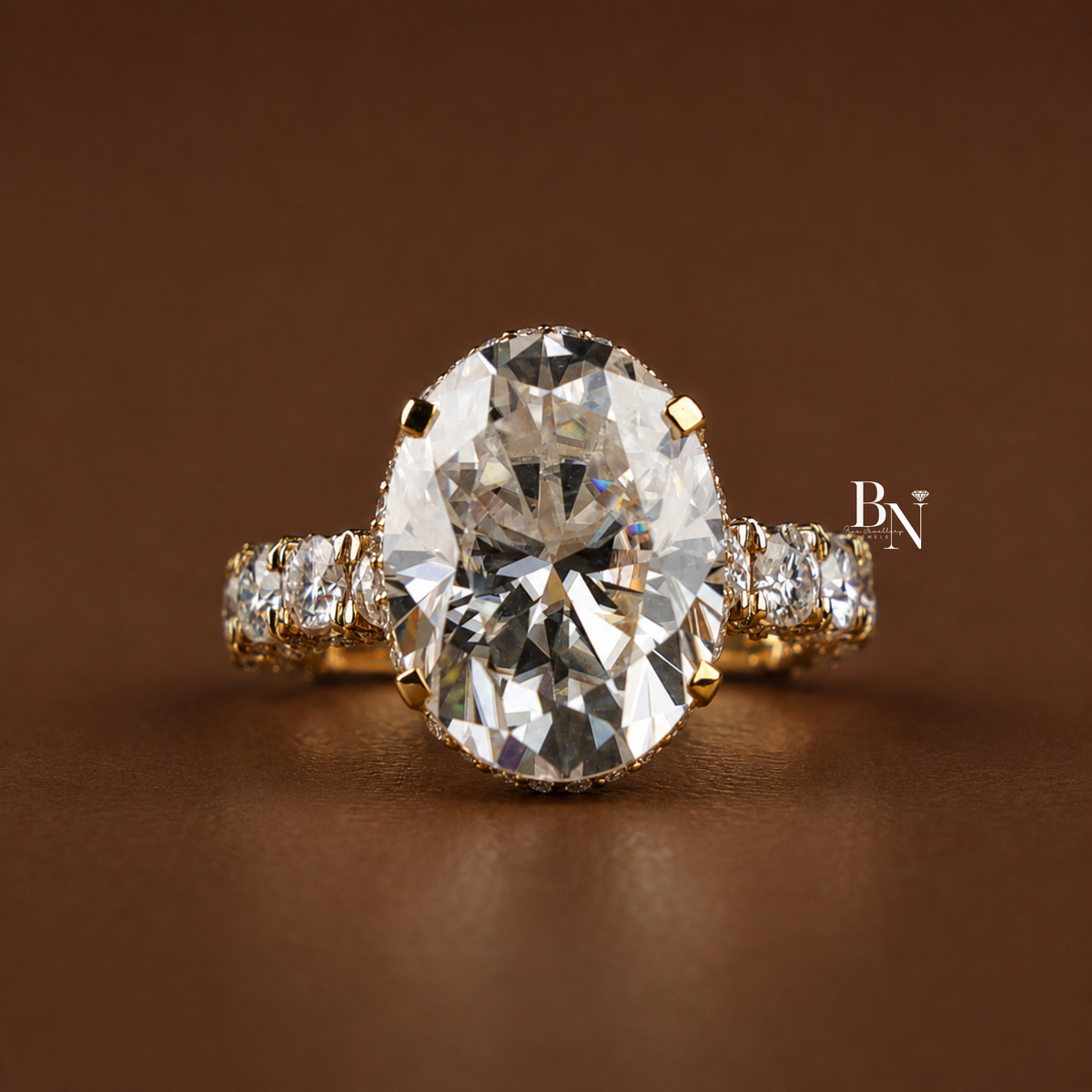 Side profile of a gold-tone engagement ring featuring a 9-carat oval-cut moissanite stone, hidden halo, 4-prong setting, and a pavé-set band against a brown background.