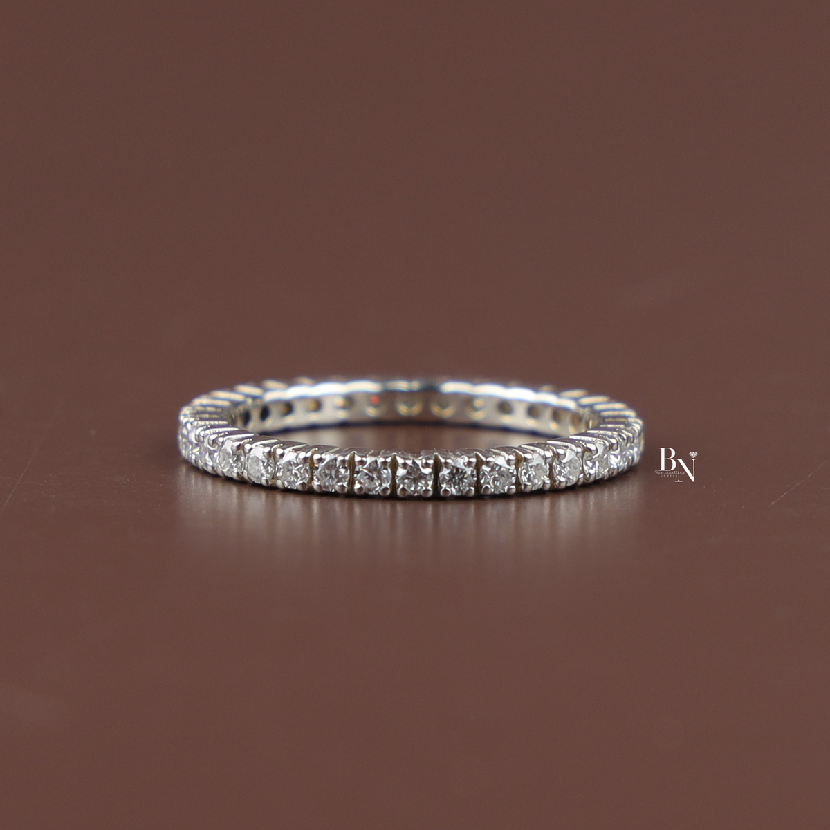 On-hand view of a 2 carat round cut lab grown diamond solitaire engagement ring featuring a silver-tone plain band and a four-prong setting.