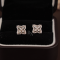 Close-up of 1.75 ctw floral moissanite earrings in rose gold with intense rainbow fire and brilliance. The unique pear petal cluster and outer cushion halo are designed to maximize sparkle for a luxury, high-performance aesthetic.