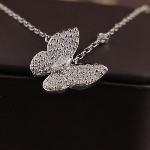 Dainty 1.00 CTW butterfly pendant necklace in 14k white gold featuring a marquise cut lab diamond center stone with brilliant pavé set lab diamonds on the wings, held in a hand to show scale and fine craftsmanship.
