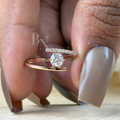 Minimalist bypass engagement ring in 14k rose gold featuring a 0.25 carat round brilliant lab grown diamond in a floating tension setting with one pave diamond side and one polished gold side.