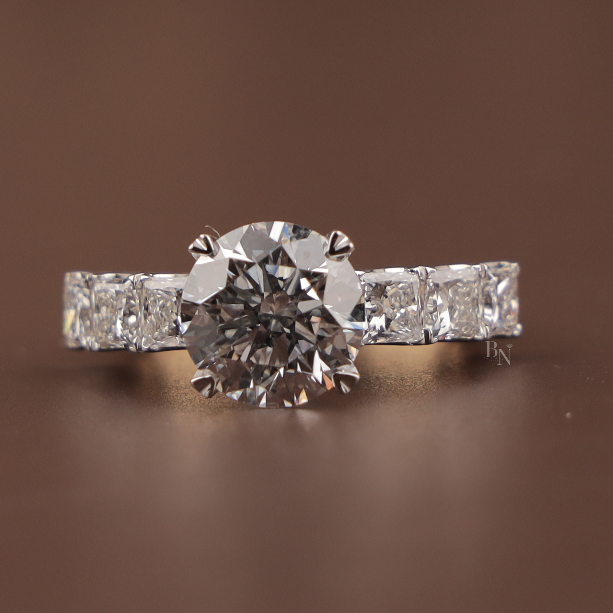 3 carat round brilliant cut lab grown diamond engagement ring with compass prongs and princess cut diamond accents on a 14k yellow gold band.