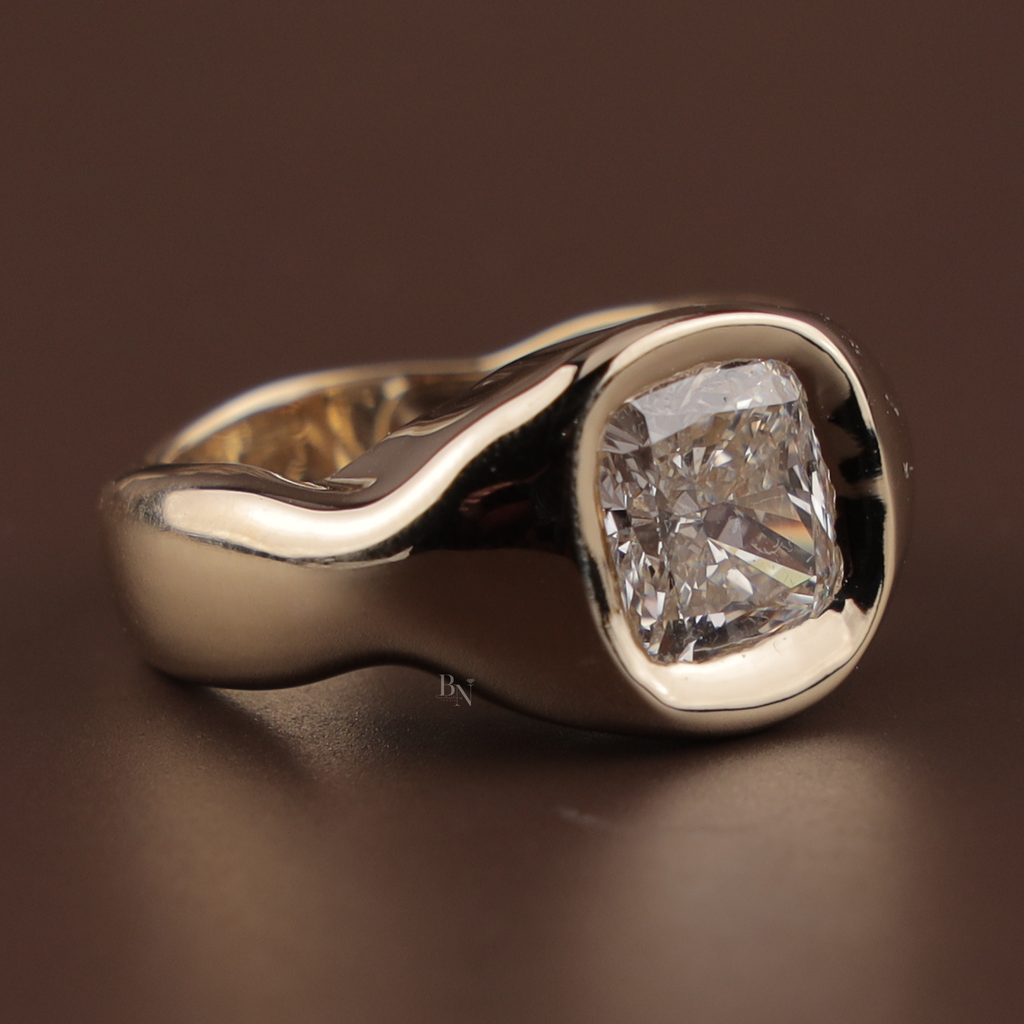3 carat elongated cushion cut lab grown diamond set in a polished 14k yellow gold organic wave sculptural bezel setting, showing a modern minimalist solitaire design with a thick comfort fit band and brilliant white light scintillation.