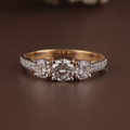 1.25 carat total weight three stone lab grown diamond engagement ring featuring three round brilliant center stones in white gold prongs on a 14k yellow gold pave-set diamond band showing white light return and crisp clarity.