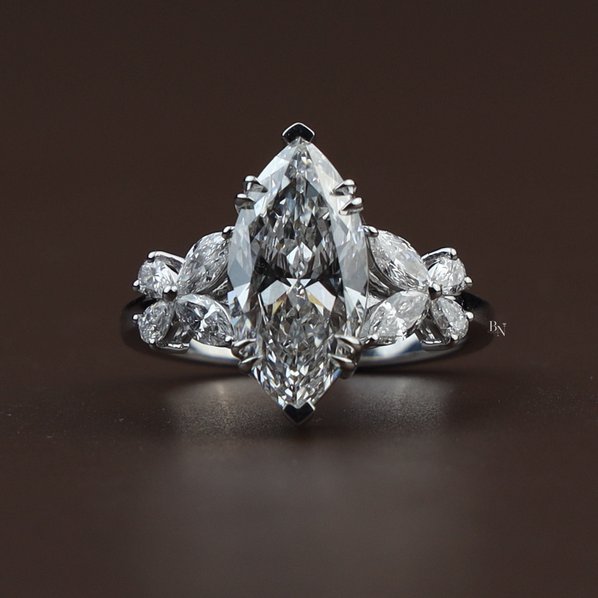 Side profile of a 3.50 carat marquise lab diamond engagement ring in 14k white gold featuring butterfly-shaped marquise side stone clusters and a decorative high-profile basket setting with v-shaped prongs.
