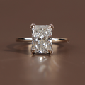 Profile view of a 3.5 carat radiant cut lab grown diamond engagement ring in 14k yellow gold featuring a sparkling hidden halo pave bridge and a delicate diamond encrusted band showcasing exceptional Type IIa clarity and icy white brilliance.