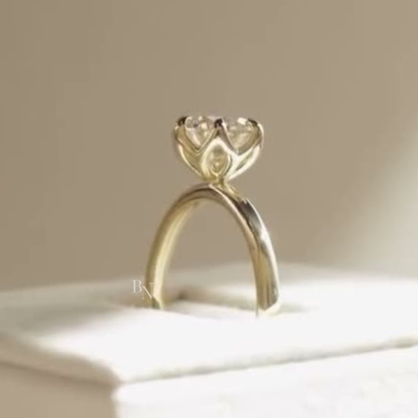 Side profile of a 2 carat round brilliant lab grown diamond engagement ring in 14k yellow gold featuring an architectural lotus petal hidden halo crown and a whisper thin polished gold band in a white velvet box.