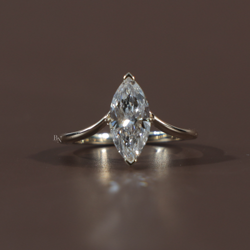 1.50 carat marquise cut lab grown diamond engagement ring in 14k white gold featuring a hidden halo under-setting and a polished tapered cathedral band shown on a hand and black silk background for luxury scale and detail.