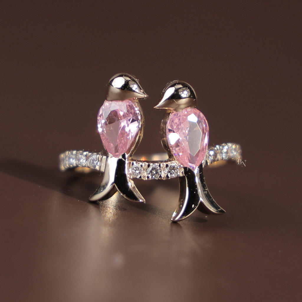 Two pear cut pink lab grown diamonds shaped as birds perched on a 14k white gold pavé branch band with round brilliant accent diamonds, romantic nature inspired bypass ring design for women.