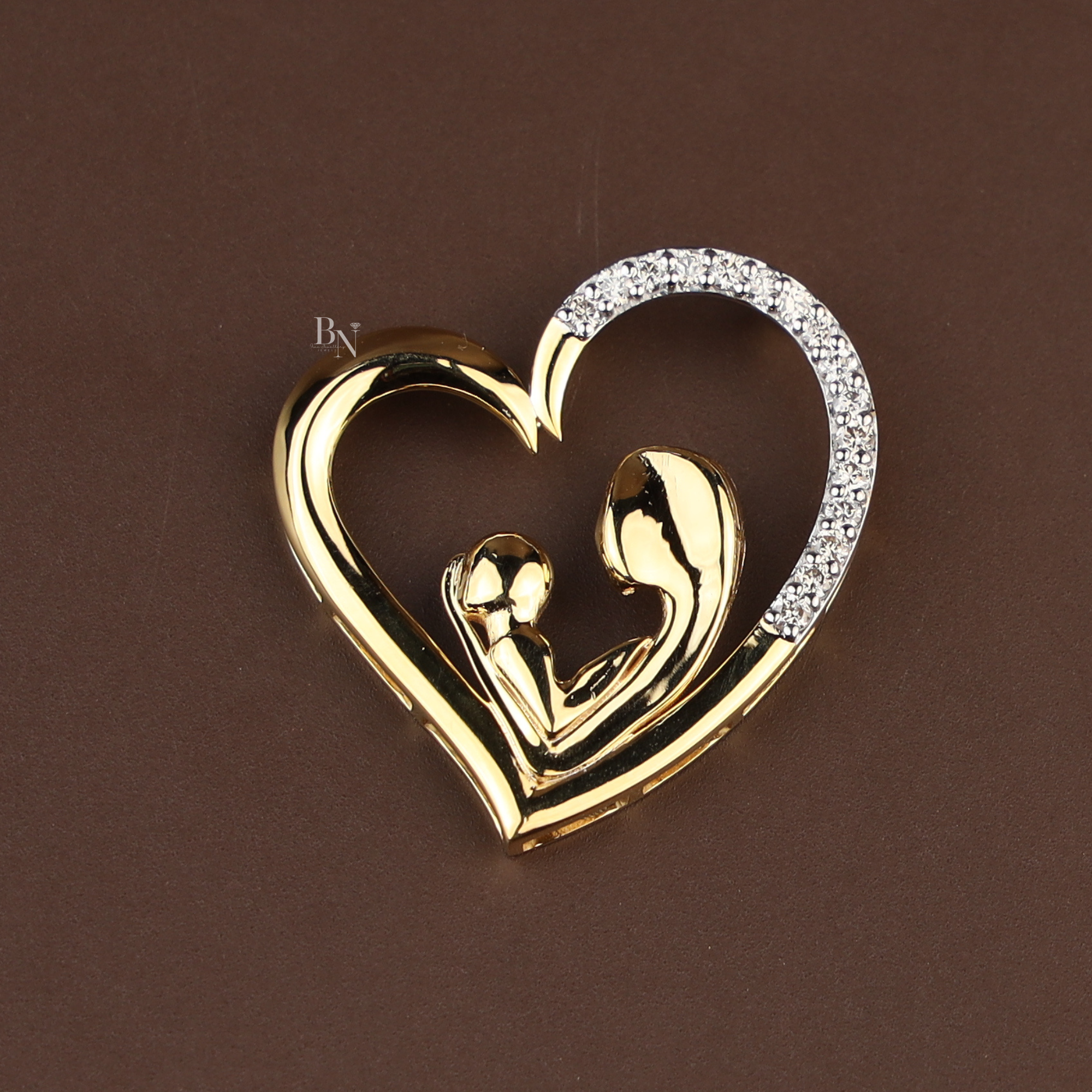 Gold heart-shaped pendant featuring a polished mother and baby silhouette design, accented with sparkling white stones on one side, shown on a delicate gold chain.