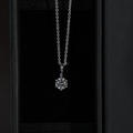 Macro view of a round brilliant cut lab grown diamond solitaire pendant in a 6-prong 14k white gold setting, hanging from a dainty cable chain, showcasing high clarity and crisp white light brilliance.