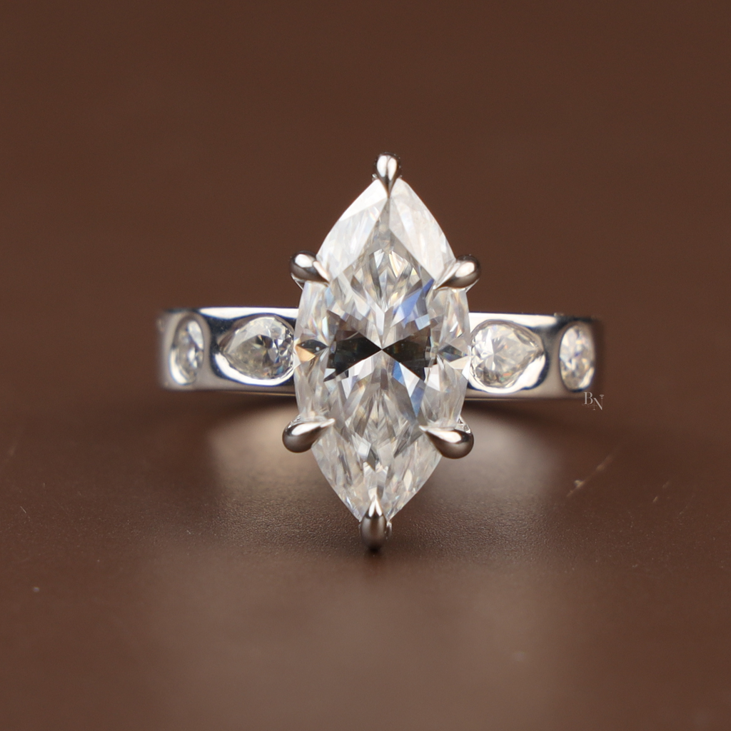 3 carat marquise cut lab grown diamond engagement ring in 14k white gold featuring a six prong V-tip setting and unique bezel set pear and round diamond accents on the band.