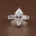 3 carat marquise cut lab grown diamond engagement ring in 14k white gold featuring a six prong V-tip setting and unique bezel set pear and round diamond accents on the band.