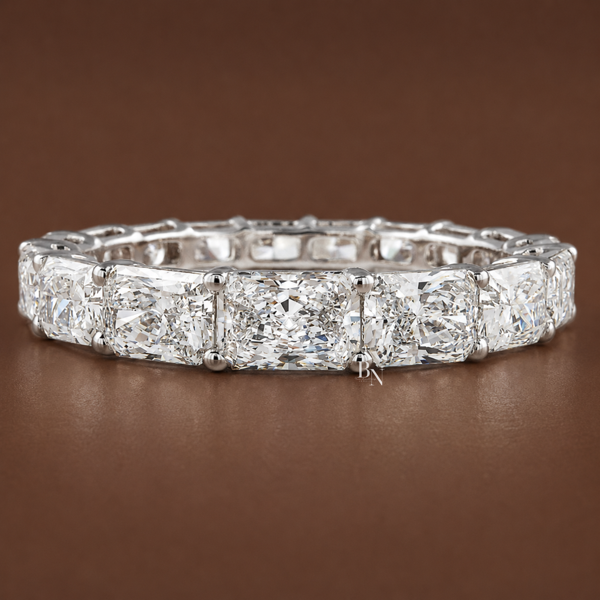 Face-up angled view of a white gold full eternity band featuring radiant-cut lab-grown diamonds that taper in size from smallest to largest.