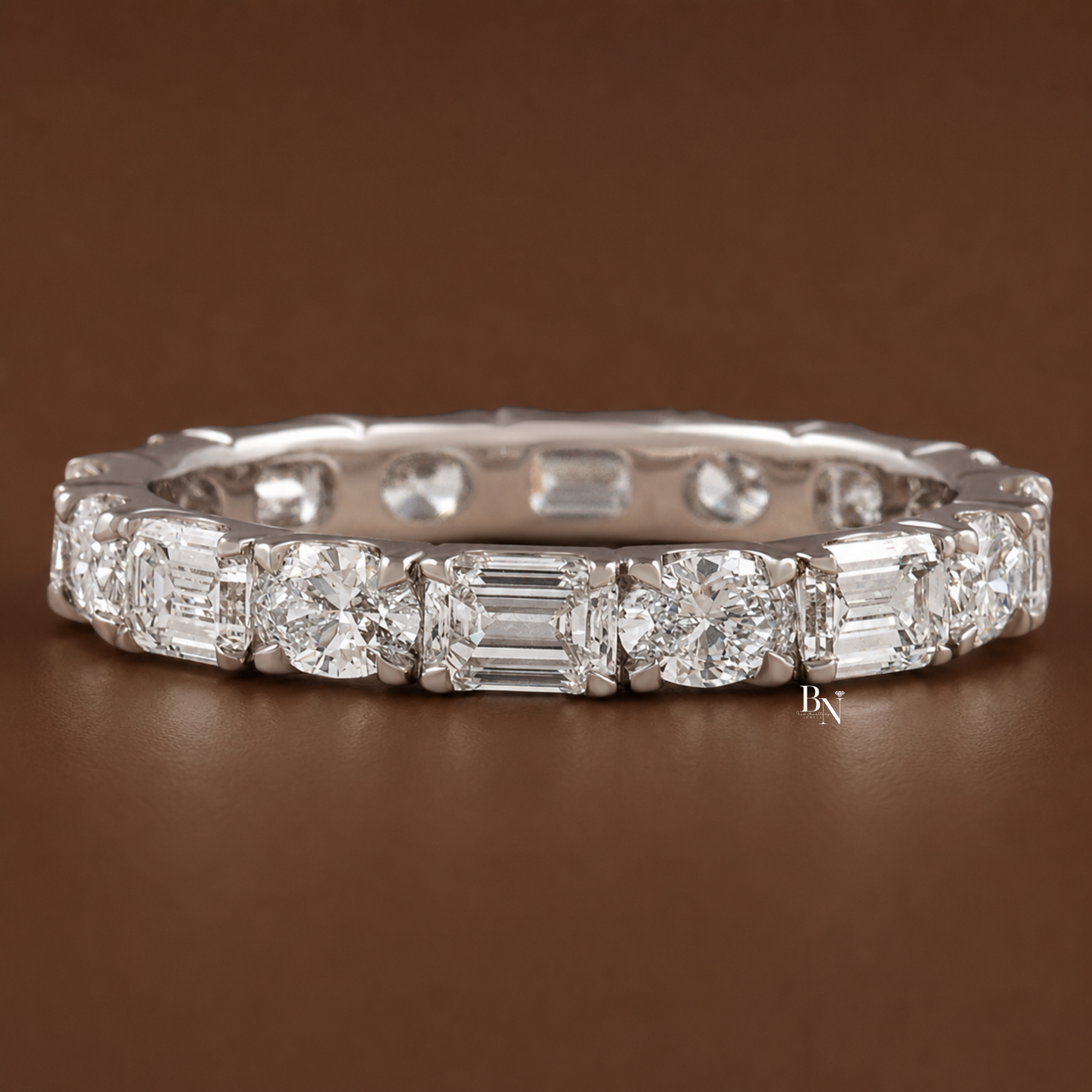 2.00 carat total weight alternating oval and emerald cut lab diamond full eternity band. Handcrafted in 14k gold, this 2.7mm wide east-west u-shape setting creates a modern, luxurious bridal stacking ring and perfect anniversary gift.