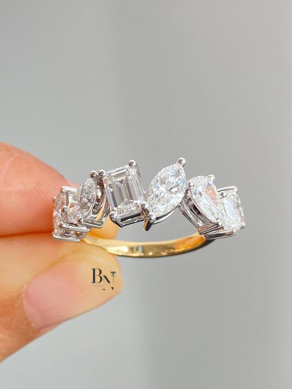 1.50 TCW multi-shape lab grown diamond wedding band with a mix of cuts including emerald and pear in a two-tone setting.