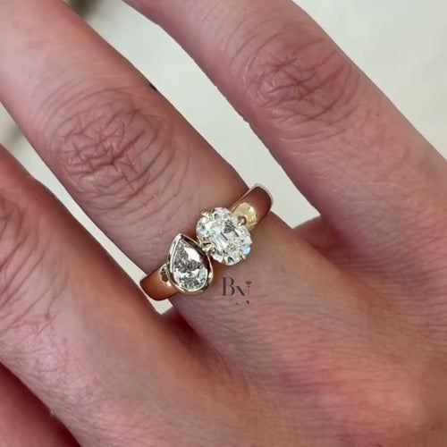 Luxurious 1.50 carat Toi et Moi lab grown diamond ring with oval and pear stones on a wide, thick cigar band in polished 14k yellow gold.
