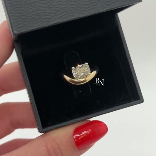 1.00 carat cushion cut lab diamond set in a sculptural yellow gold bypass engagement ring, featuring a semi-bezel setting for a sleek, modern, and low-profile look.