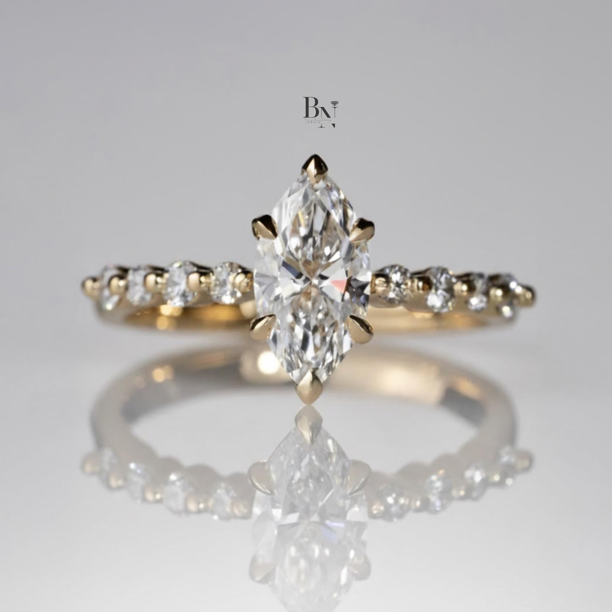 Elegant 1.00ct marquise cut lab grown diamond engagement ring in 14k yellow gold. Features a dainty band with graduated round pave accent diamonds and six prongs.