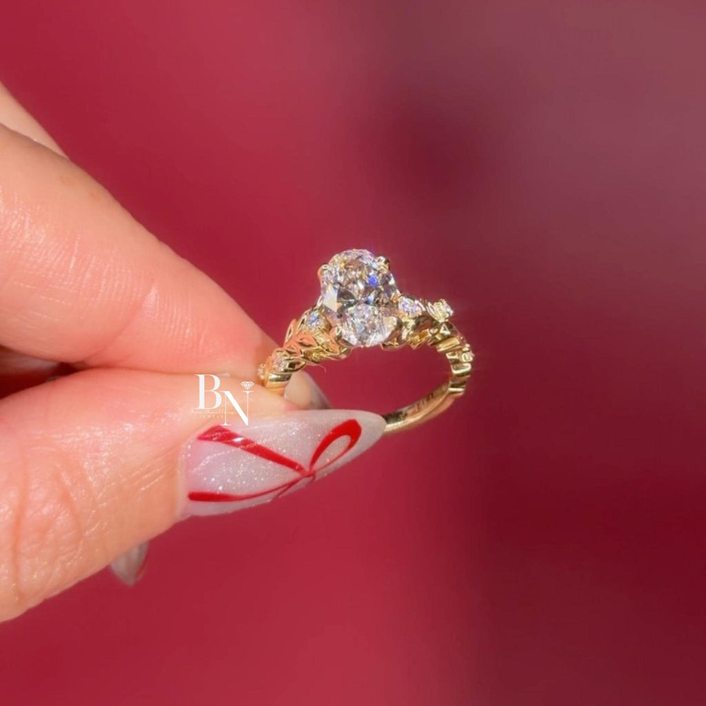 Exquisite 3.00ct elongated oval lab grown diamond engagement ring in 14k yellow gold. Features a romantic, nature-inspired vine floral accent band with marquise and round pave diamonds on the shoulders. A unique statement solitaire.