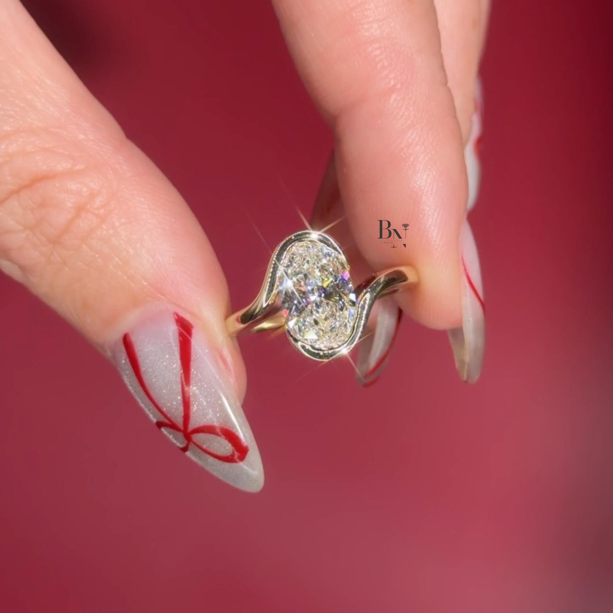 Artistic 3.00ct elongated oval lab grown diamond engagement ring in 14k yellow gold. Features a unique vertical swirl bypass setting with a protective semi bezel on the side.