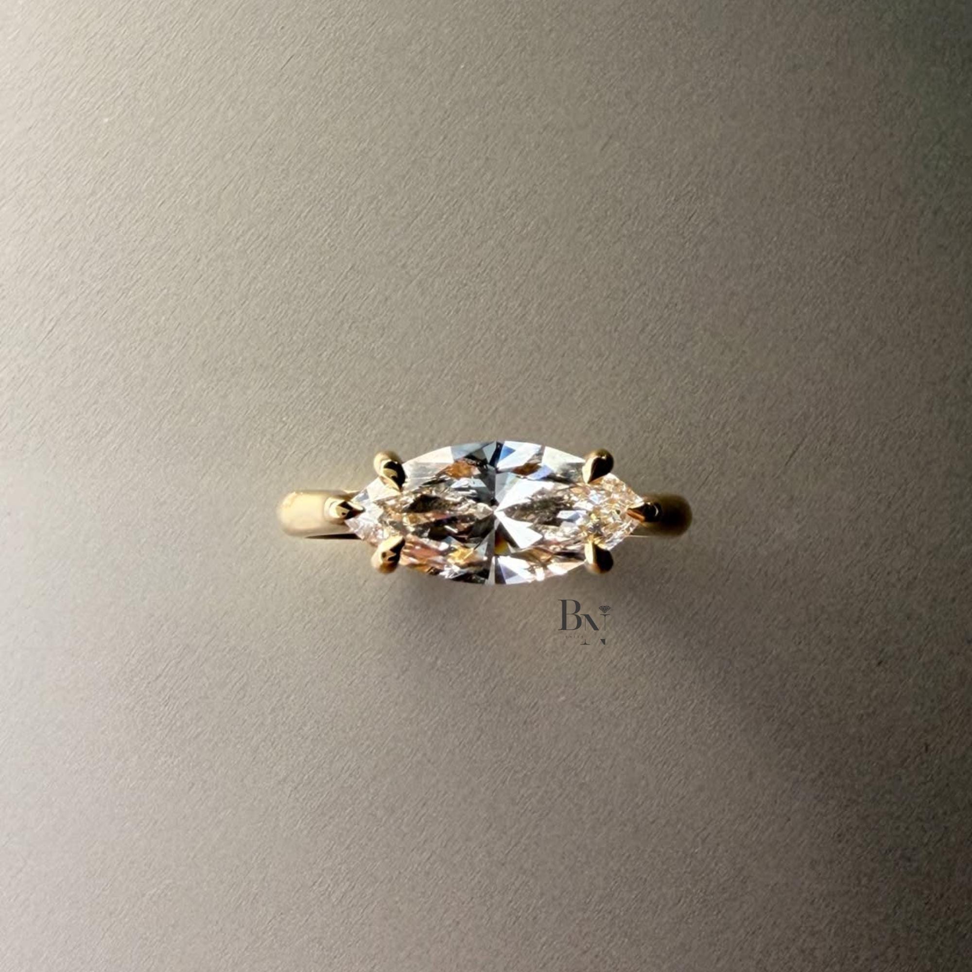 Exquisite 3.00ct horizontal marquise cut lab grown diamond engagement ring in 14k yellow gold. Features an east west setting with a dainty graduated pave accent band.